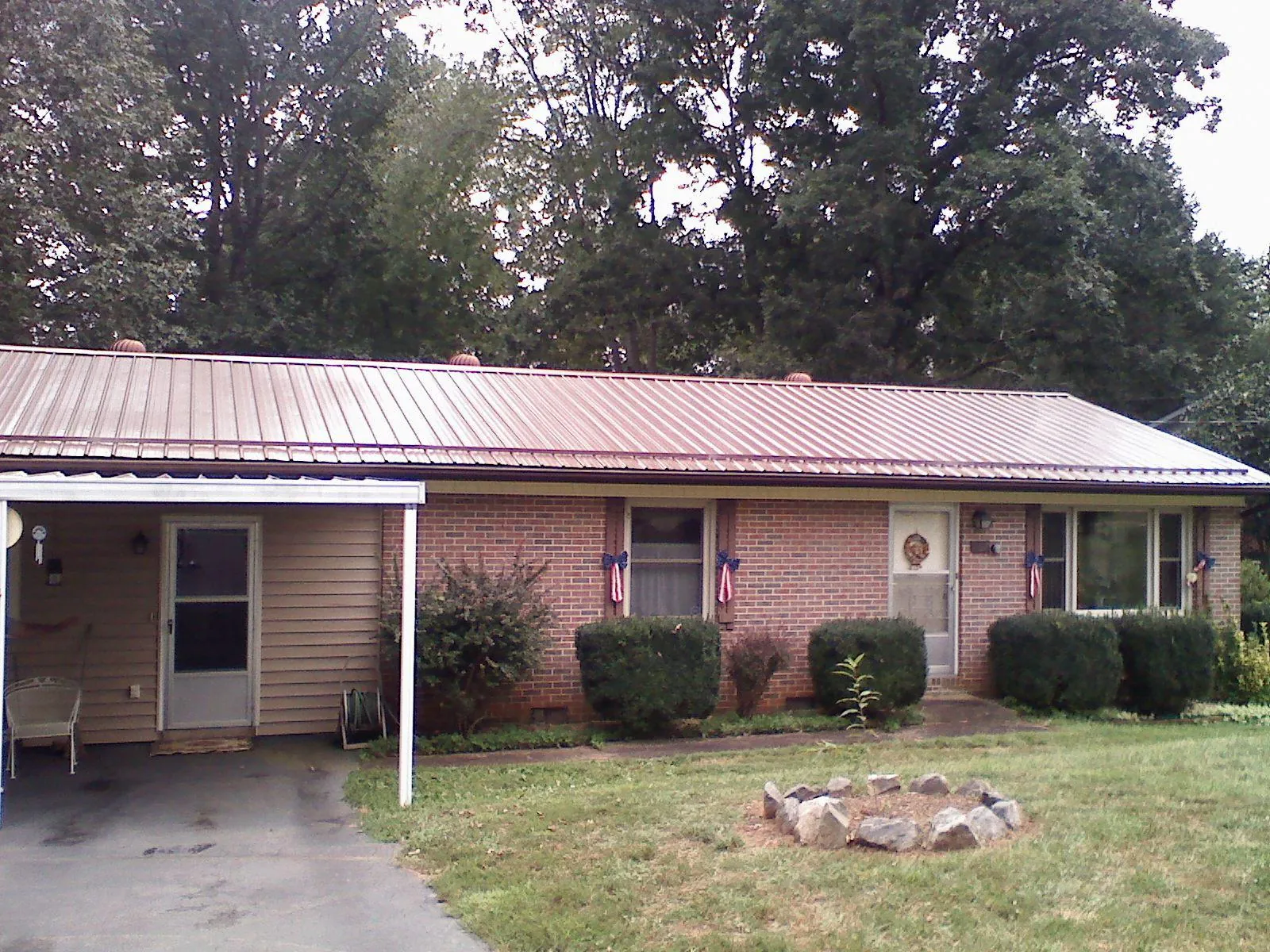 Bronze metal roof and carport on a brick ranch home — Roof Repair work by our crew in Waynesburg