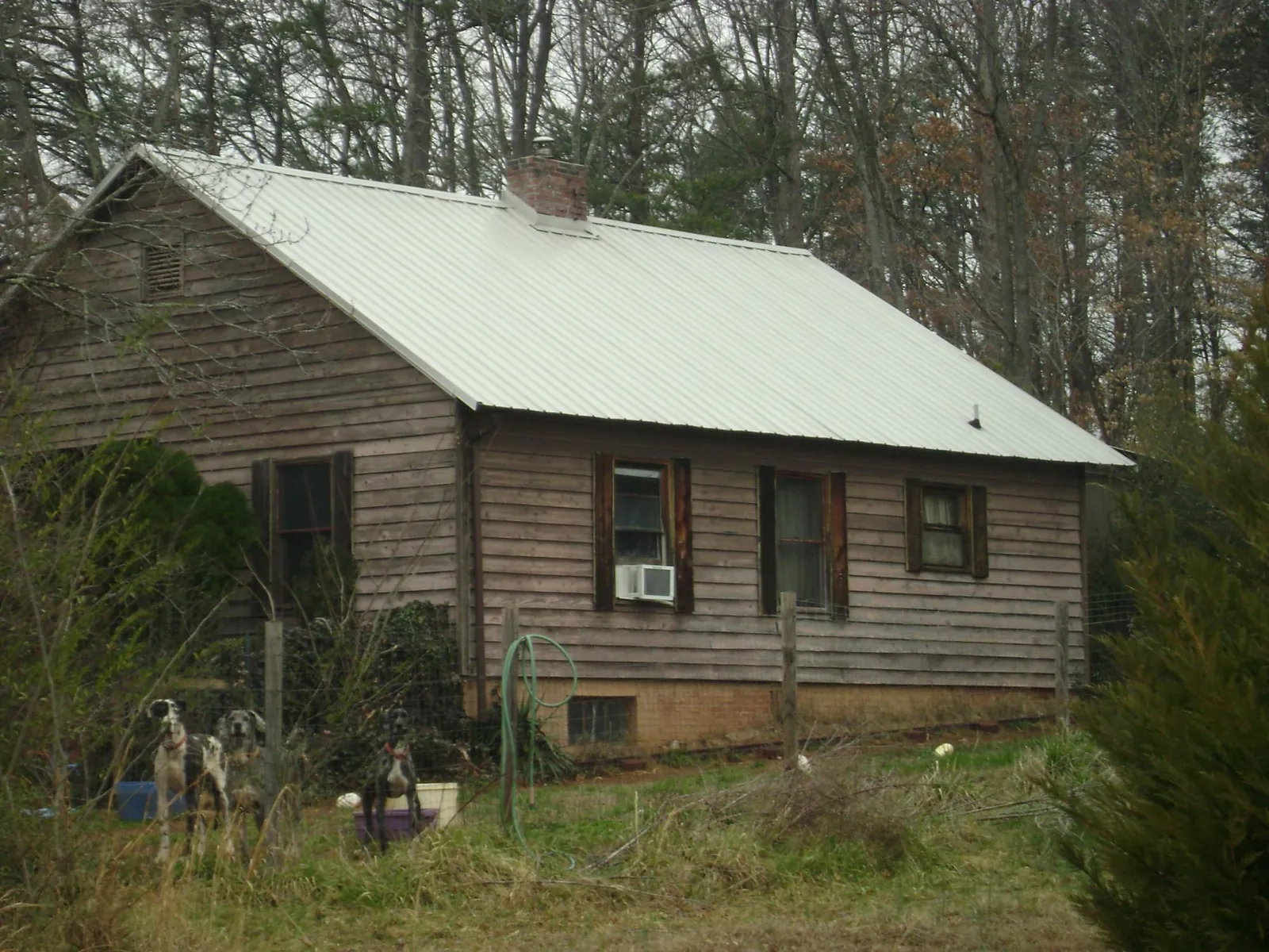 White metal roof on an old wood sided farmhouse, from a Asphalt Shingle Roof Repair job in Waynesburg